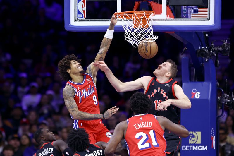 PHILADELPHIA, PENNSYLVANIA - DECEMBER 22: Kelly Oubre Jr. #9 of the Philadelphia 76ers dunks past Jakob Poeltl #19 of the Toronto Raptors during the second quarter at the Wells Fargo Center on December 22, 2023 in Philadelphia, Pennsylvania. NOTE TO USER: User expressly acknowledges and agrees that, by downloading and or using this photograph, User is consenting to the terms and conditions of the Getty Images License Agreement. (Photo by Tim Nwachukwu/Getty Images)