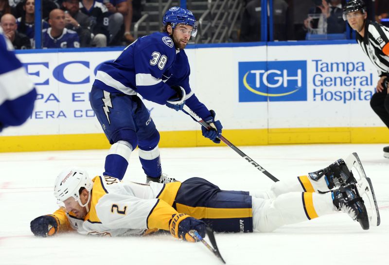 Oct 28, 2024; Tampa, Florida, USA; Tampa Bay Lightning left wing Brandon Hagel (38) shoots against Nashville Predators Luke Schenn (2) during the third period at Amalie Arena. Mandatory Credit: Kim Klement Neitzel-Imagn Images