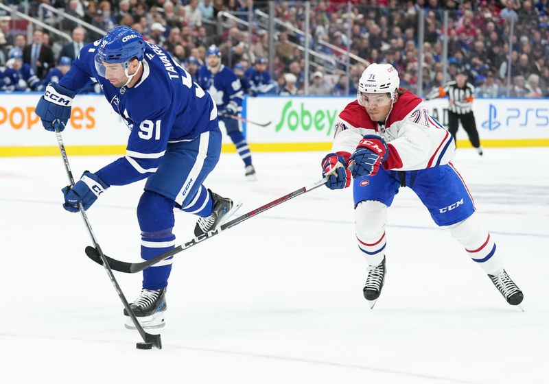 Nov 9, 2024; Toronto, Ontario, CAN; Toronto Maple Leafs center John Tavares (91) attempts a shot on goal as Montreal Canadiens center Jake Evans (71) tries to defend during the first period at Scotiabank Arena. Mandatory Credit: Nick Turchiaro-Imagn Images