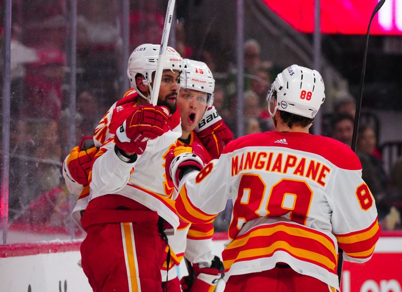 Mar 10, 2024; Raleigh, North Carolina, USA;  Calgary Flames left wing Dryden Hunt (15) celebrates his goal with center Oliver Kylington (58) and left wing Andrew Mangiapane (88) against the Carolina Hurricanes during the second period  at PNC Arena. Mandatory Credit: James Guillory-USA TODAY Sports