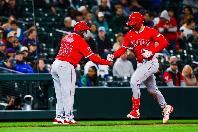 Apr 29, 2025; Seattle, Washington, USA; Los Angeles Angels catcher Logan O'Hoppe (14) bumps fists with third base coach Eric Young Sr. (85) after hitting a solo-home run against the Seattle Mariners during the seventh inning at T-Mobile Park. Mandatory Credit: Joe Nicholson-Imagn Images