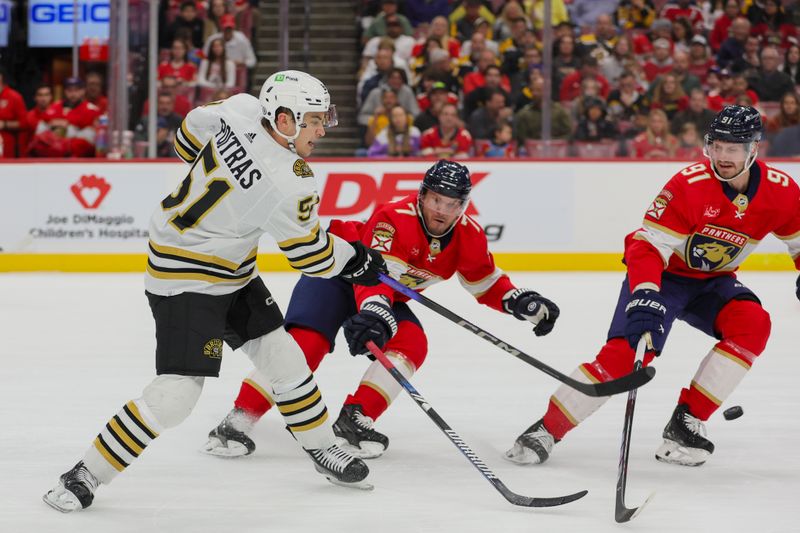 Nov 22, 2023; Sunrise, Florida, USA; Boston Bruins center Matthew Poitras (51) shoots the puck as Florida Panthers defenseman Dmitry Kulikov (7) and defenseman Oliver Ekman-Larsson (91) defend during the first period at Amerant Bank Arena. Mandatory Credit: Sam Navarro-USA TODAY Sports