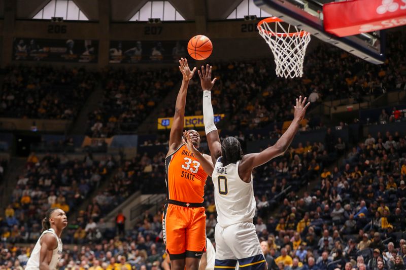 Jan 4, 2025; Morgantown, West Virginia, USA; Oklahoma State Cowboys forward Abou Ousmane (33) shoots over West Virginia Mountaineers center Eduardo Andre (0) during the second half at WVU Coliseum. Mandatory Credit: Ben Queen-Imagn Images