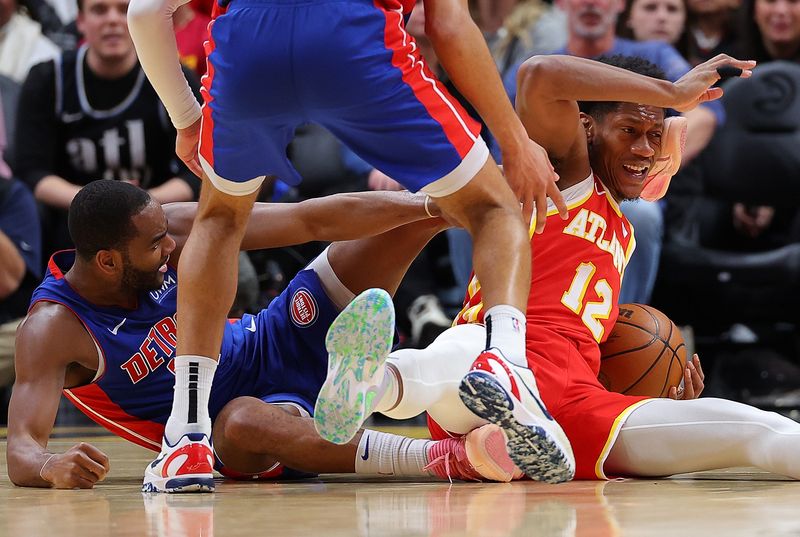 ATLANTA, GEORGIA - DECEMBER 18:  De'Andre Hunter #12 of the Atlanta Hawks draws a foul as he battles for a loose ball against Alec Burks #14 of the Detroit Pistons during the fourth quarter at State Farm Arena on December 18, 2023 in Atlanta, Georgia.  NOTE TO USER: User expressly acknowledges and agrees that, by downloading and/or using this photograph, user is consenting to the terms and conditions of the Getty Images License Agreement.  (Photo by Kevin C. Cox/Getty Images)