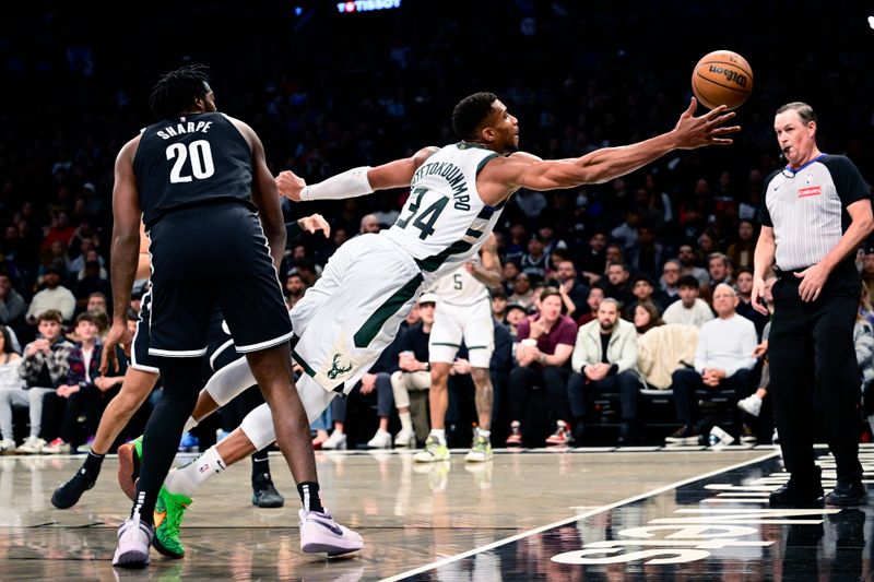 NEW YORK, NEW YORK - DECEMBER 08:  Giannis Antetokounmpo #34 of the Milwaukee Bucks dives for the ball against Day'Ron Sharpe #20 of the Brooklyn Nets during the first half at Barclays Center on December 08, 2024 in New York City. NOTE TO USER: User expressly acknowledges and agrees that, by downloading and or using this Photograph, user is consenting to the terms and conditions of the Getty Images License Agreement.  (Photo by Steven Ryan/Getty Images)