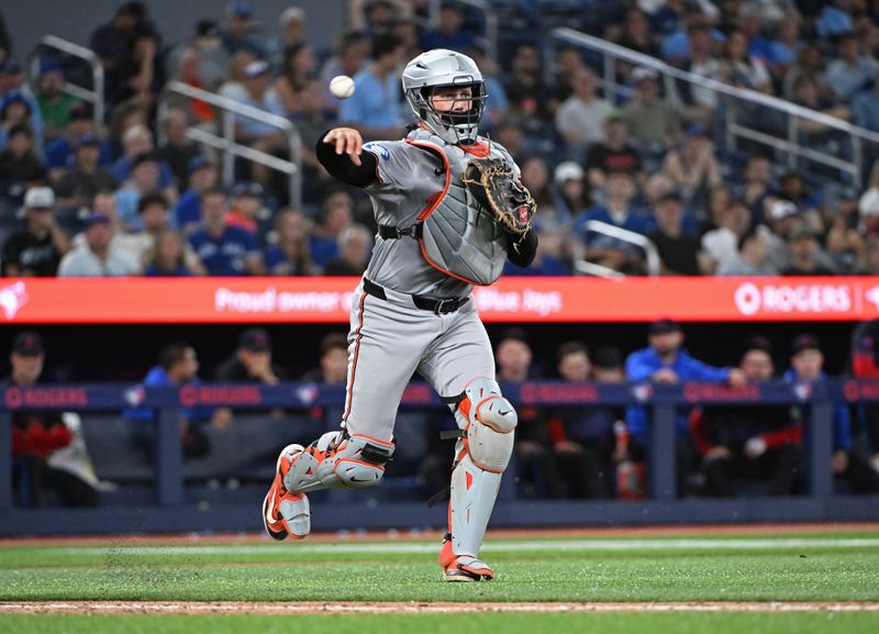 Aug 8, 2024; Toronto, Ontario, CAN; Baltimore Orioles catcher Adley Rutschman (35) field a ground ball by Toronto Blue Jays right field Addison Barger (47) in the eight inning at Rogers Centre. Mandatory Credit: Gerry Angus-USA TODAY Sports