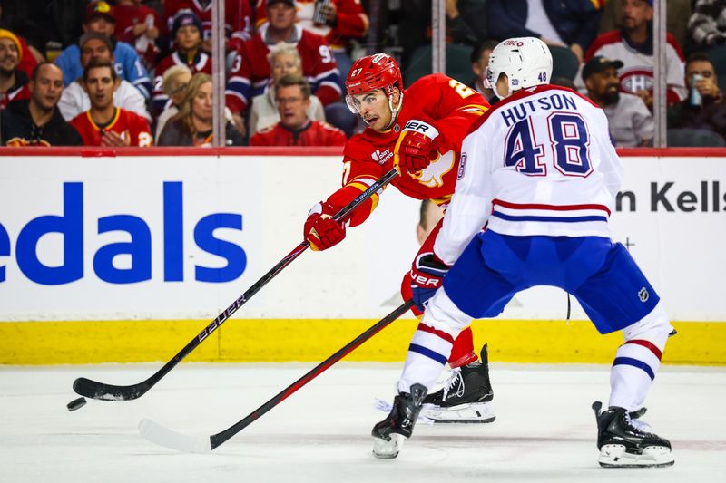 Oct 22, 2025; Calgary, Alberta, CAN; Calgary Flames right wing Matt Coronato (27) shoots the puck in front of Montreal Canadiens defenseman Lane Hutson (48) during the second period at Scotiabank Saddledome. Mandatory Credit: Sergei Belski-Imagn Images