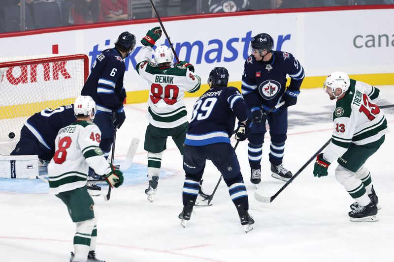 Sep 21, 2025; Winnipeg, Manitoba, CAN; Minnesota Wild center Yakov Trenin (13) scores on Winnipeg Jets goaltender Isaac Poulter (30) in overtime at Canada Life Centre. Mandatory Credit: James Carey Lauder-Imagn Images