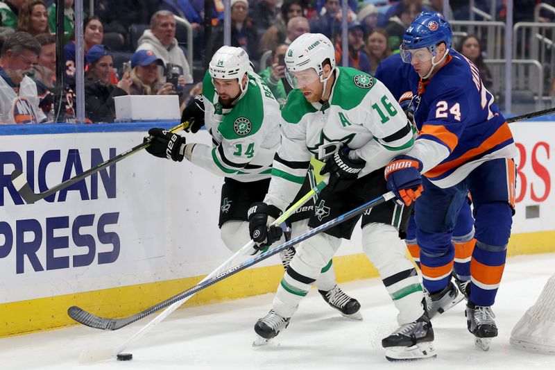 Jan 21, 2024; Elmont, New York, USA; New York Islanders defenseman Scott Mayfield (24) fights for the puck against Dallas Stars center Joe Pavelski (16) and left wing Jamie Benn (14) during the third period at UBS Arena. Mandatory Credit: Brad Penner-USA TODAY Sports