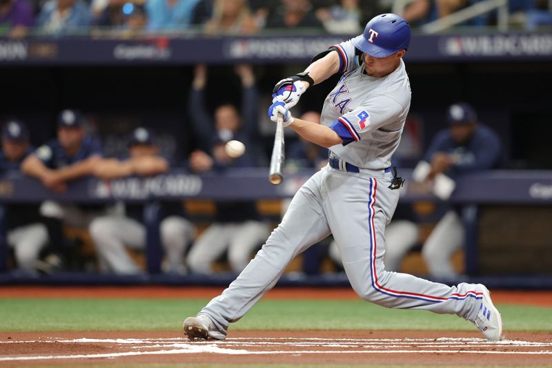 Oct 4, 2023; St. Petersburg, Florida, USA; Texas Rangers shortstop Corey Seager (5) hits a double against the Tampa Bay Rays in the first inning during game two of the Wildcard series for the 2023 MLB playoffs at Tropicana Field. Mandatory Credit: Nathan Ray Seebeck-USA TODAY Sports