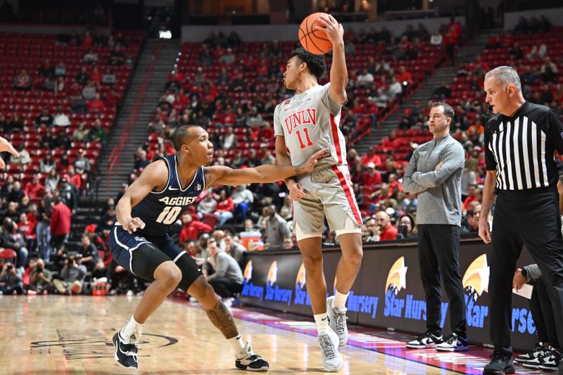 Jan 13, 2024; Las Vegas, Nevada, USA; Utah State Aggies guard Darius Brown II (10) defends against UNLV Rebels guard Dedan Thomas Jr. (11) in the first half at Thomas & Mack Center. Mandatory Credit: Candice Ward-USA TODAY Sports