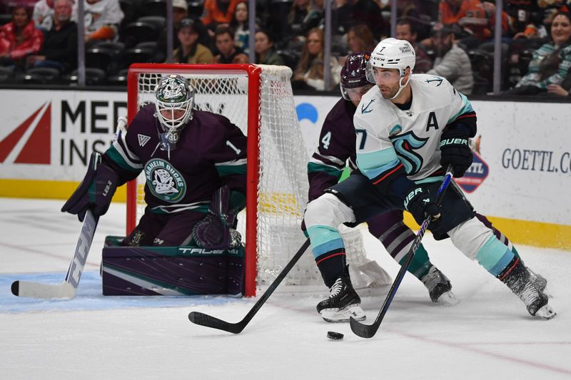 Dec 23, 2023; Anaheim, California, USA; Seattle Kraken right wing Jordan Eberle (7) moves the puck as Anaheim Ducks defenseman Cam Fowler (4) helps goaltender Lukas Dostal (1) defend the goal during the first period at Honda Center. Mandatory Credit: Gary A. Vasquez-USA TODAY Sports