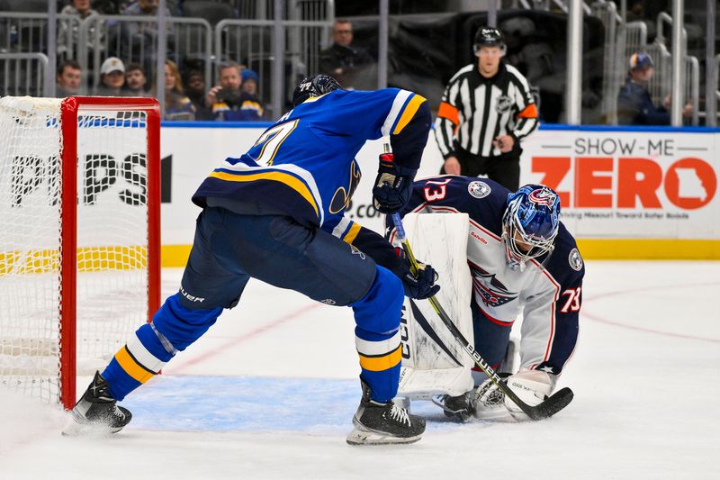 Oct 1, 2024; St. Louis, Missouri, USA;  Columbus Blue Jackets goaltender Jet Greaves (73) defends the net against St. Louis Blues defenseman Pierre-Olivier Joseph (77) during the second period at Enterprise Center. Mandatory Credit: Jeff Curry-Imagn Images