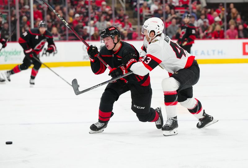 Nov 16, 2024; Raleigh, North Carolina, USA;  Carolina Hurricanes right wing Jackson Blake (53) is checked by Ottawa Senators defenseman Tyler Kleven (43) during the third period at Lenovo Center. Mandatory Credit: James Guillory-Imagn Images