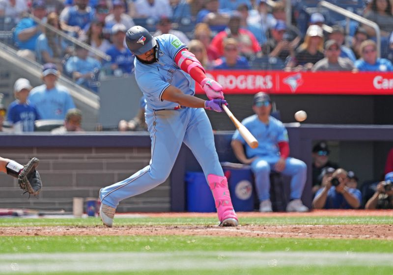 Aug 25, 2024; Toronto, Ontario, CAN; Toronto Blue Jays first base Vladimir Guerrero Jr. (27) hits an RBI double against the Los Angeles Angels during the fifth inning at Rogers Centre. Mandatory Credit: Nick Turchiaro-USA TODAY Sports