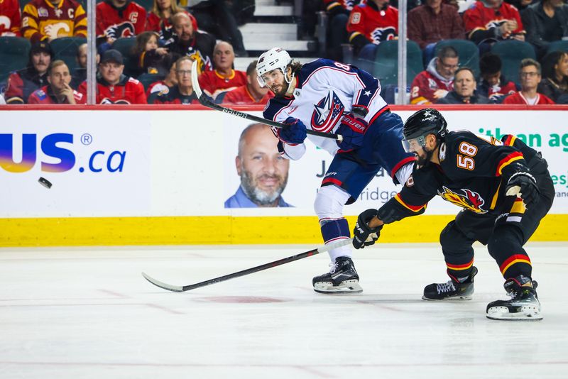 Jan 25, 2024; Calgary, Alberta, CAN; Columbus Blue Jackets right wing Kirill Marchenko (86) shoots the puck in front of Calgary Flames defenseman Oliver Kylington (58) during the first period at Scotiabank Saddledome. Mandatory Credit: Sergei Belski-USA TODAY Sports