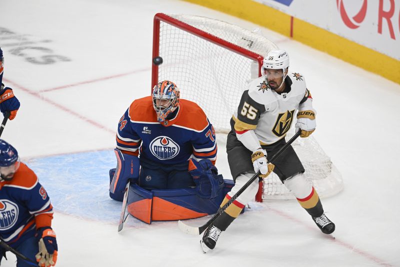 May 12, 2025; Edmonton, Alberta, CAN;  Edmonton Oilers goalie Stuart Skinner (74) battles for the puck with Vegas Golden Knights right winger Keegan Kolesar (55) during the second period in game three of the second round of the 2025 Stanley Cup Playoffs at Rogers Place. Mandatory Credit: Walter Tychnowicz-Imagn Images