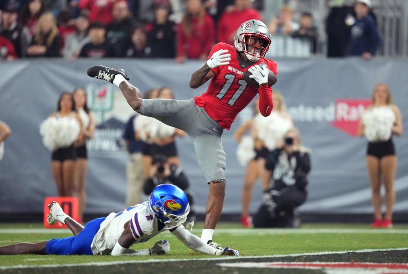 Dec 26, 2023; Phoenix, AZ, USA; UNLV Rebels wide receiver Ricky White (11) catches a touchdown pass against Kansas Jayhawks cornerback Cobee Bryant (2) during the second half at Chase Field. Mandatory Credit: Joe Camporeale-USA TODAY Sports