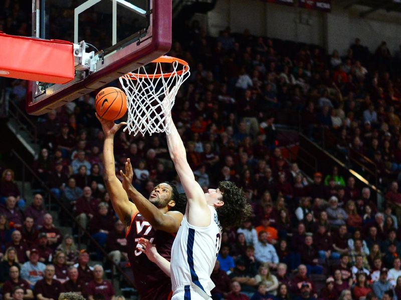 Feb 19, 2024; Blacksburg, Virginia, USA;Virginia Tech Hokies forward Mylyjael Poteat (34) shoots a shot as Virginia Cavaliers forward Blake Buchanan (0) defends during the second half at Cassell Coliseum. Mandatory Credit: Brian Bishop-USA TODAY Sports