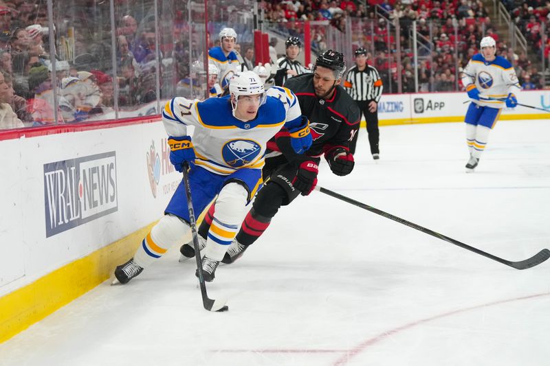 Jan 19, 2026; Raleigh, North Carolina, USA;  Buffalo Sabres center Ryan McLeod (71) skates with the puck past Carolina Hurricanes defenseman K'andre Miller (19) during the second period at Lenovo Center. Mandatory Credit: James Guillory-Imagn Images