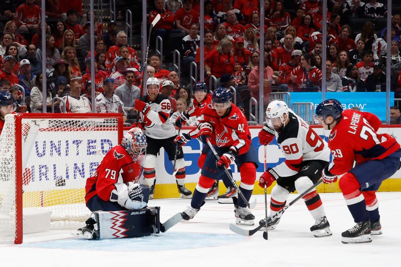 Oct 12, 2024; Washington, District of Columbia, USA; Washington Capitals goaltender Charlie Lindgren (79) makes a save on New Jersey Devils left wing Tomas Tatar (90) as Capitals center Hendrix Lapierre (29) defends in the second period at Capital One Arena. Mandatory Credit: Geoff Burke-Imagn Images