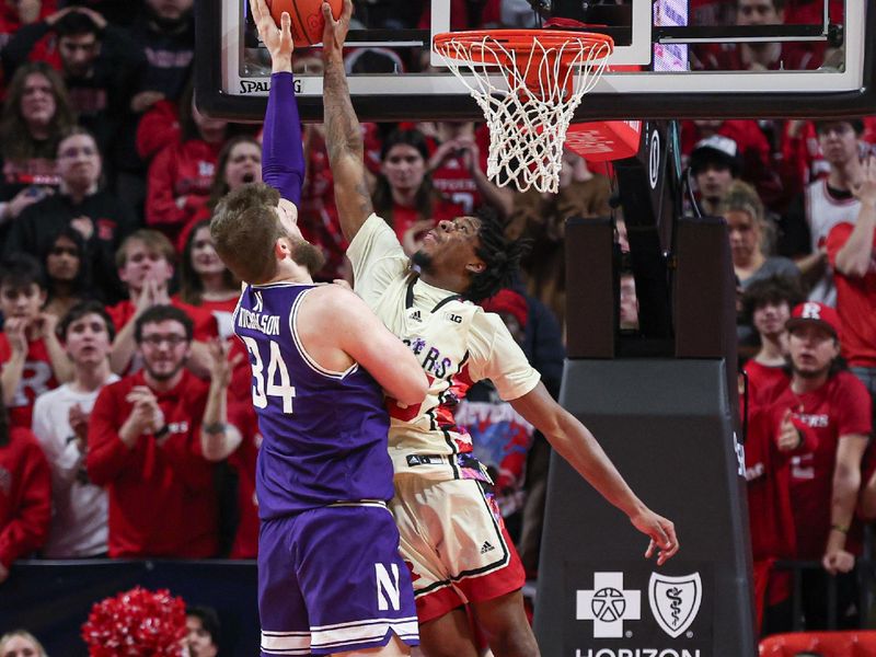 Feb 15, 2024; Piscataway, New Jersey, USA; Rutgers Scarlet Knights guard Jeremiah Williams (25) blocks a shot by Northwestern Wildcats center Matthew Nicholson (34)  during the second half at Jersey Mike's Arena. Mandatory Credit: Vincent Carchietta-USA TODAY Sports