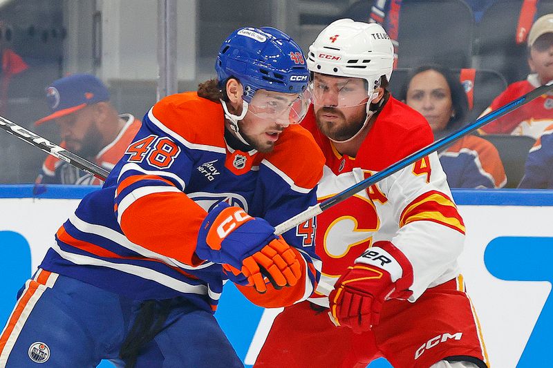 Oct 8, 2025; Edmonton, Alberta, CAN; Edmonton Oilers forward Noah Philp (48) and Calgary Flames defensemen Rasmus Andersson (4) battle for position during the first period at Rogers Place. Mandatory Credit: Perry Nelson-Imagn Images