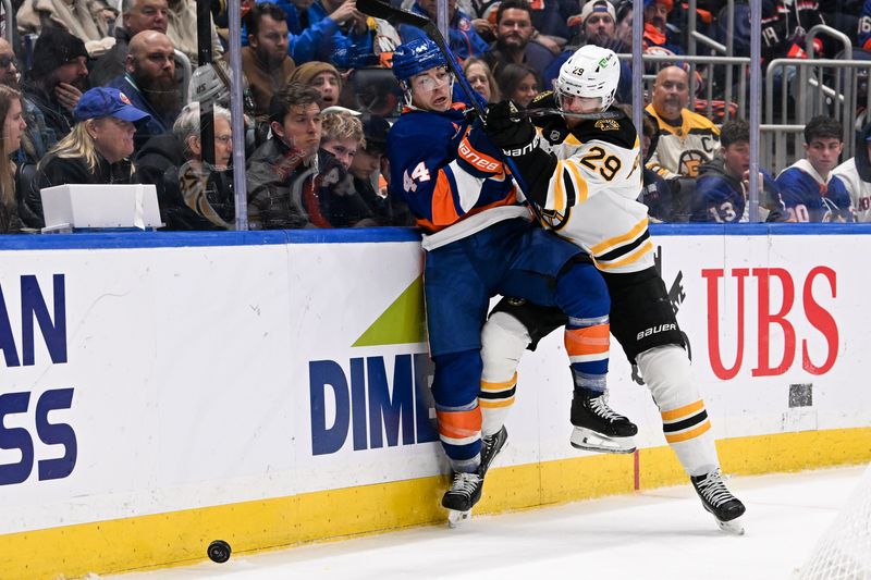 Nov 27, 2024; Elmont, New York, USA;  Boston Bruins defenseman Parker Wotherspoon (29) checks New York Islanders center Jean-Gabriel Pageau (44) into the boards during the second period at UBS Arena. Mandatory Credit: Dennis Schneidler-Imagn Images