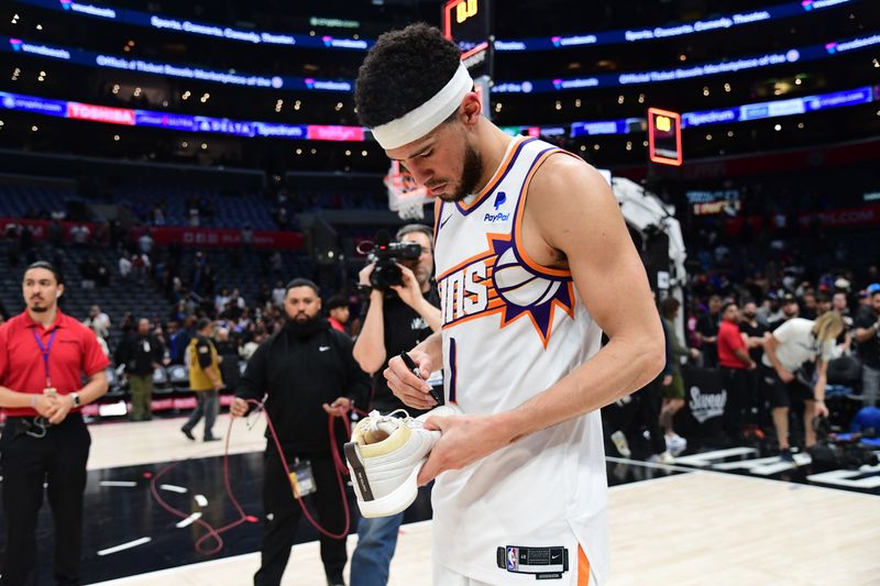 LOS ANGELES, CA - APRIL 10: Devin Booker #1 of the Phoenix Suns signs sneakers after the game against the LA Clippers on April 10, 2024 at Crypto.Com Arena in Los Angeles, California. NOTE TO USER: User expressly acknowledges and agrees that, by downloading and/or using this Photograph, user is consenting to the terms and conditions of the Getty Images License Agreement. Mandatory Copyright Notice: Copyright 2024 NBAE (Photo by Adam Pantozzi/NBAE via Getty Images)