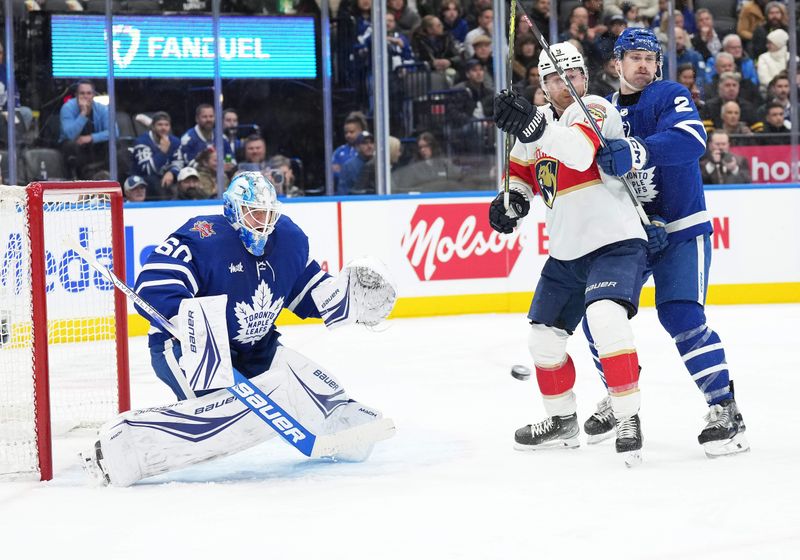 Nov 28, 2023; Toronto, Ontario, CAN; Florida Panthers center Sam Bennett (9) battles of the puck with Toronto Maple Leafs defenceman  Simon Benoit (2) during the second period at Scotiabank Arena. Mandatory Credit: Nick Turchiaro-USA TODAY Sports