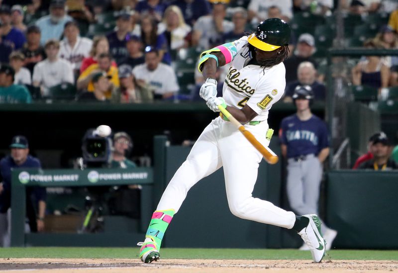 May 5, 2025; West Sacramento, California, USA; Athletics right fielder Lawrence Butler (4) hits a RBI single against the Seattle Mariners during the fourth inning at Sutter Health Park. Mandatory Credit: Dennis Lee-Imagn Images