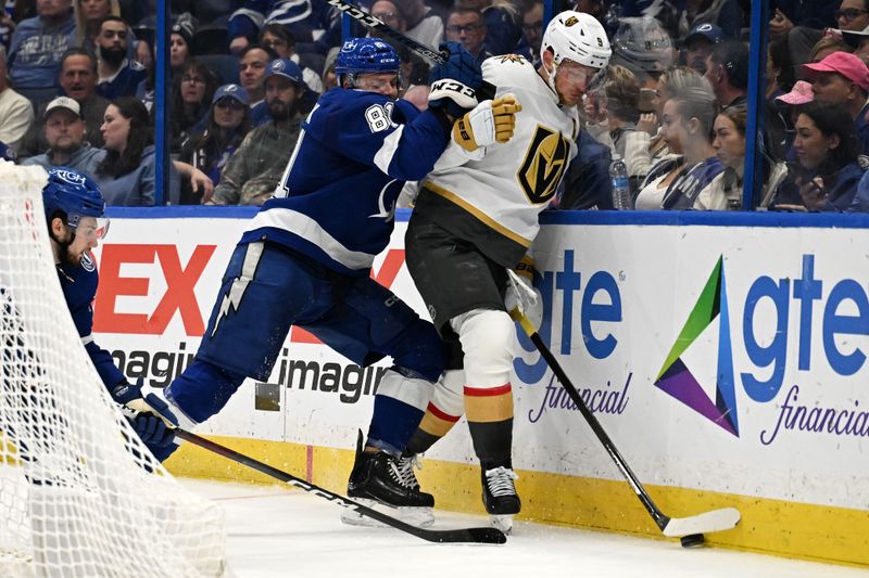 Dec 21, 2023; Tampa, Florida, USA; Tampa Bay Lightning defensemen Erik Cernak (81) and Las Vegas Golden Knights center Jack Eichel (9) look to gain control of the puck in the second period at Amalie Arena. Mandatory Credit: Jonathan Dyer-USA TODAY Sports