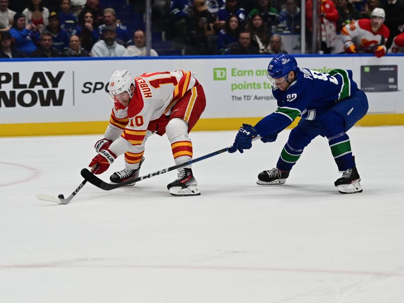 Mar 23, 2024; Vancouver, British Columbia, CAN; Calgary Flames forward Jonathan Huerdeau (10) skates with puck against Vancouver Canucks defenseman Ian Cole (82) during the second period at Rogers Arena. Mandatory Credit: Simon Fearn-USA TODAY Sports