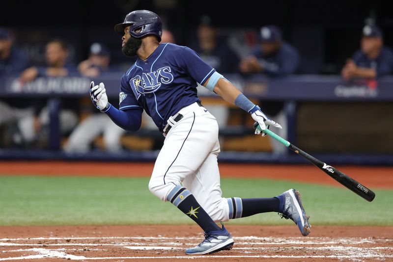 Oct 4, 2023; St. Petersburg, Florida, USA; Tampa Bay Rays center fielder Manuel Margot (13) hits a single against the Texas Rangers in the second inning during game two of the Wildcard series for the 2023 MLB playoffs at Tropicana Field. Mandatory Credit: Nathan Ray Seebeck-USA TODAY Sports