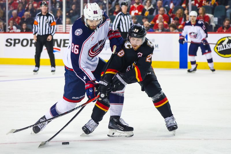 Jan 25, 2024; Calgary, Alberta, CAN; Columbus Blue Jackets right wing Kirill Marchenko (86) and Calgary Flames center Elias Lindholm (28) battles for the puck during the second period at Scotiabank Saddledome. Mandatory Credit: Sergei Belski-USA TODAY Sports