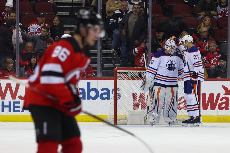 Dec 21, 2023; Newark, New Jersey, USA; Edmonton Oilers goaltender Calvin Pickard (30) and defenseman Darnell Nurse (25) celebrate their win over the New Jersey Devils during the third period at Prudential Center. Mandatory Credit: Ed Mulholland-USA TODAY Sports