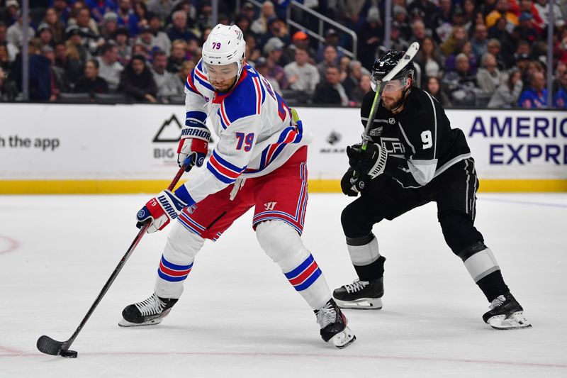 Jan 20, 2024; Los Angeles, California, USA; New York Rangers defenseman K'Andre Miller (79) moves the puck ahead of Los Angeles Kings right wing Adrian Kempe (9) durng the second period at Crypto.com Arena. Mandatory Credit: Gary A. Vasquez-USA TODAY Sports