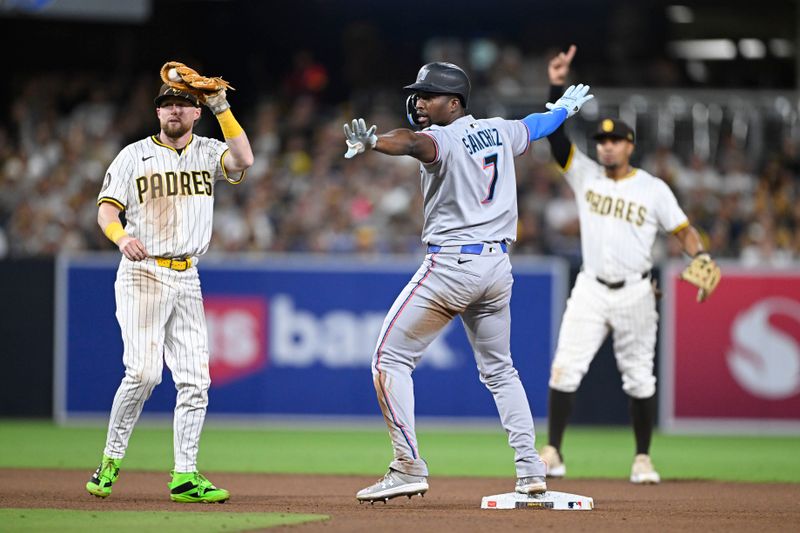 May 27, 2025; San Diego, California, USA; Miami Marlins outfielder Jesús Sánchez (7) signals safe at second base as San Diego Padres second baseman Jake Cronenworth (9) holds up the ball during the seventh inning at Petco Park. Sánchez was out on the play. Mandatory Credit: Denis Poroy-Imagn Images