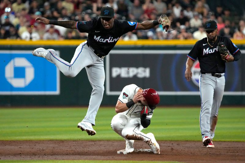 May 24, 2024; Phoenix, Arizona, USA; Miami Marlins shortstop Tim Anderson (7) gets the force out on Arizona Diamondbacks shortstop Blaze Alexander (9) in the second inning at Chase Field. Mandatory Credit: Rick Scuteri-USA TODAY Sports