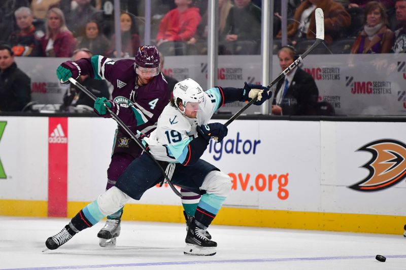 Apr 5, 2024; Anaheim, California, USA; Anaheim Ducks defenseman Cam Fowler (4) plays for the puck against Seattle Kraken left wing Jared McCann (19) during the third period at Honda Center. Mandatory Credit: Gary A. Vasquez-USA TODAY Sports