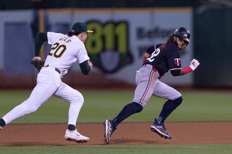 Jun 21, 2024; Oakland, California, USA; Oakland Athletics second base Zack Gelof (20) chases down Minnesota Twins outfielder Austin Martin (82) during the eighth inning at Oakland-Alameda County Coliseum. Mandatory Credit: Stan Szeto-USA TODAY Sports