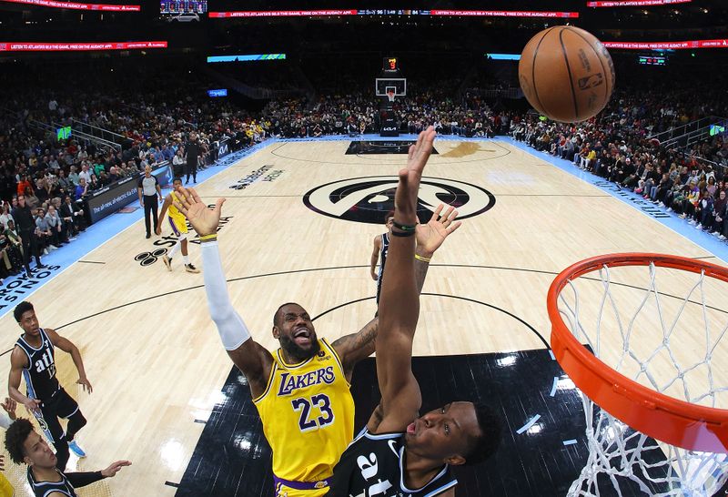 ATLANTA, GEORGIA - JANUARY 30:  LeBron James #23 of the Los Angeles Lakers draws a foul as he attacks the basket against Onyeka Okongwu #17 of the Atlanta Hawks during the third quarter at State Farm Arena on January 30, 2024 in Atlanta, Georgia.  NOTE TO USER: User expressly acknowledges and agrees that, by downloading and/or using this photograph, user is consenting to the terms and conditions of the Getty Images License Agreement.  (Photo by Kevin C. Cox/Getty Images). (Photo by Kevin C. Cox/Getty Images)