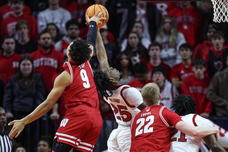 Jan 6, 2025; Piscataway, New Jersey, USA; Wisconsin Badgers guard John Tonje (9) blocks a shot by Rutgers Scarlet Knights guard Jeremiah Williams (25) during the first half at Jersey Mike's Arena. Mandatory Credit: Vincent Carchietta-Imagn Images 