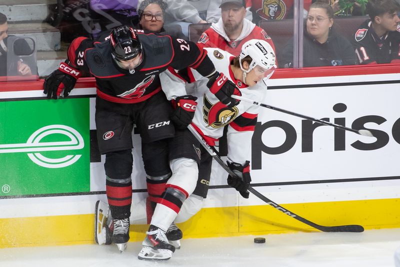 Mar 17, 2024; Ottawa, Ontario, CAN; Carolina Hurricanes right wing Stefan Noesen (23) battles with Ottawa Senators center Ridly Greig (71) for control of the puck in the third period at the Canadian Tire Centre. Mandatory Credit: Marc DesRosiers-USA TODAY Sports