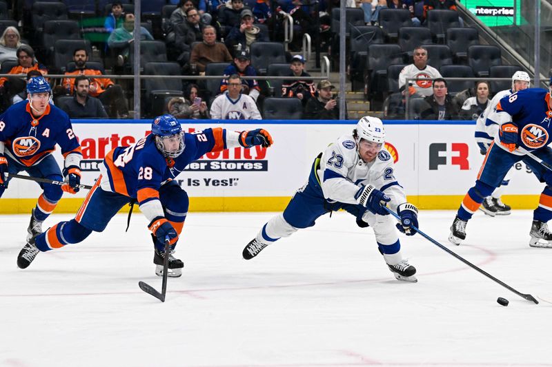 Feb 8, 2024; Elmont, New York, USA; Tampa Bay Lightning center Michael Eyssimont (23) reaches for a loose puck defended by New York Islanders defenseman Alexander Romanov (28) during the third period at UBS Arena. Mandatory Credit: Dennis Schneidler-USA TODAY Sports