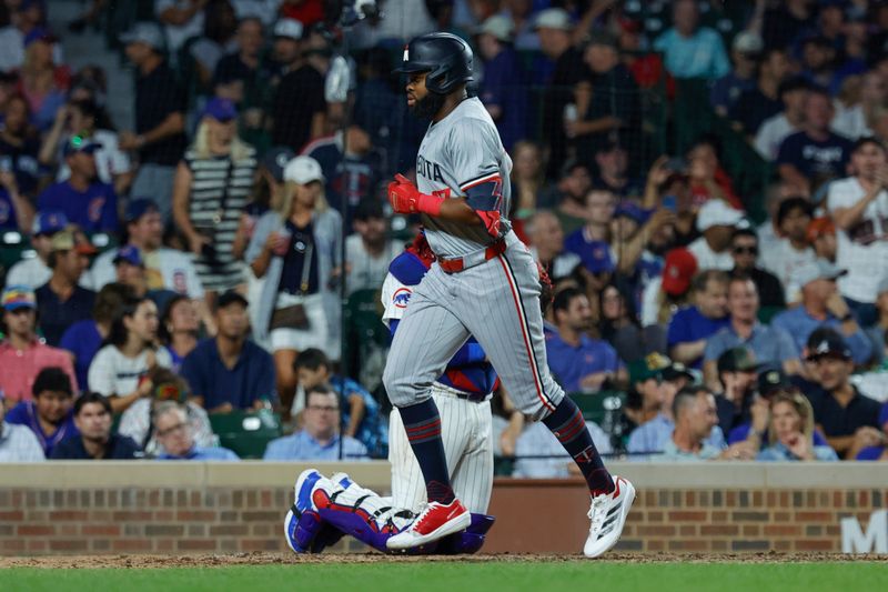 Aug 5, 2024; Chicago, Illinois, USA; Minnesota Twins outfielder Manuel Margot (13) crosses home plate after hitting a solo home run against the Chicago Cubs during the fifth inning at Wrigley Field. Mandatory Credit: Kamil Krzaczynski-USA TODAY Sports
