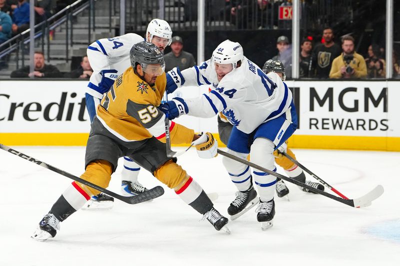 Jan 15, 2026; Las Vegas, Nevada, USA; Vegas Golden Knights right wing Keegan Kolesar (55) scores on a shot as Toronto Maple Leafs defenseman Morgan Rielly (44) applies a check during the second period at T-Mobile Arena. Mandatory Credit: Stephen R. Sylvanie-Imagn Images