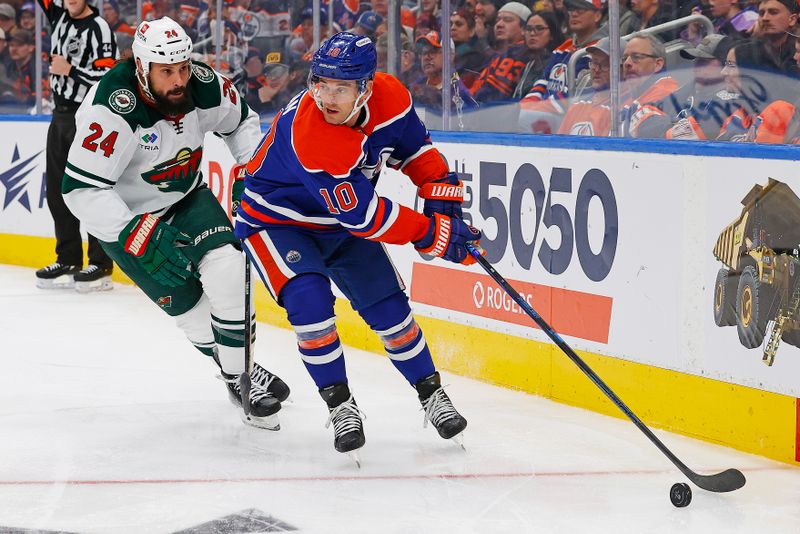 Nov 21, 2024; Edmonton, Alberta, CAN; Edmonton Oilers forward Derek Ryan (10) protects the puck from Minnesota Wild defensemen Zach Bogosian (24) during the third period at Rogers Place. Mandatory Credit: Perry Nelson-Imagn Images