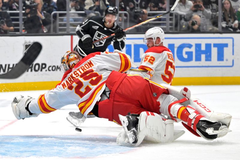 Apr 11, 2024; Los Angeles, California, USA; Calgary Flames goaltender Jacob Markstrom (25) reaches for the puck on a shot by Los Angeles Kings left wing Kevin Fiala (22) in the second period at Crypto.com Arena. Mandatory Credit: Jayne Kamin-Oncea-USA TODAY Sports