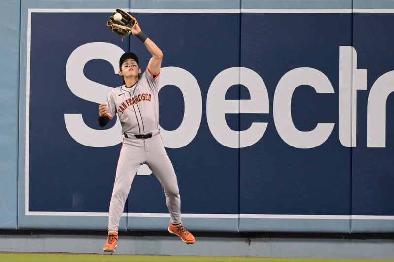 Apr 2, 2024; Los Angeles, California, USA;  San Francisco Giants center fielder Jung Hoo Lee (51) catches a ball at the wall off Los Angeles Dodgers left fielder Kiki Hernandez (8) in the third inning at Dodger Stadium. Mandatory Credit: Jayne Kamin-Oncea-USA TODAY Sports